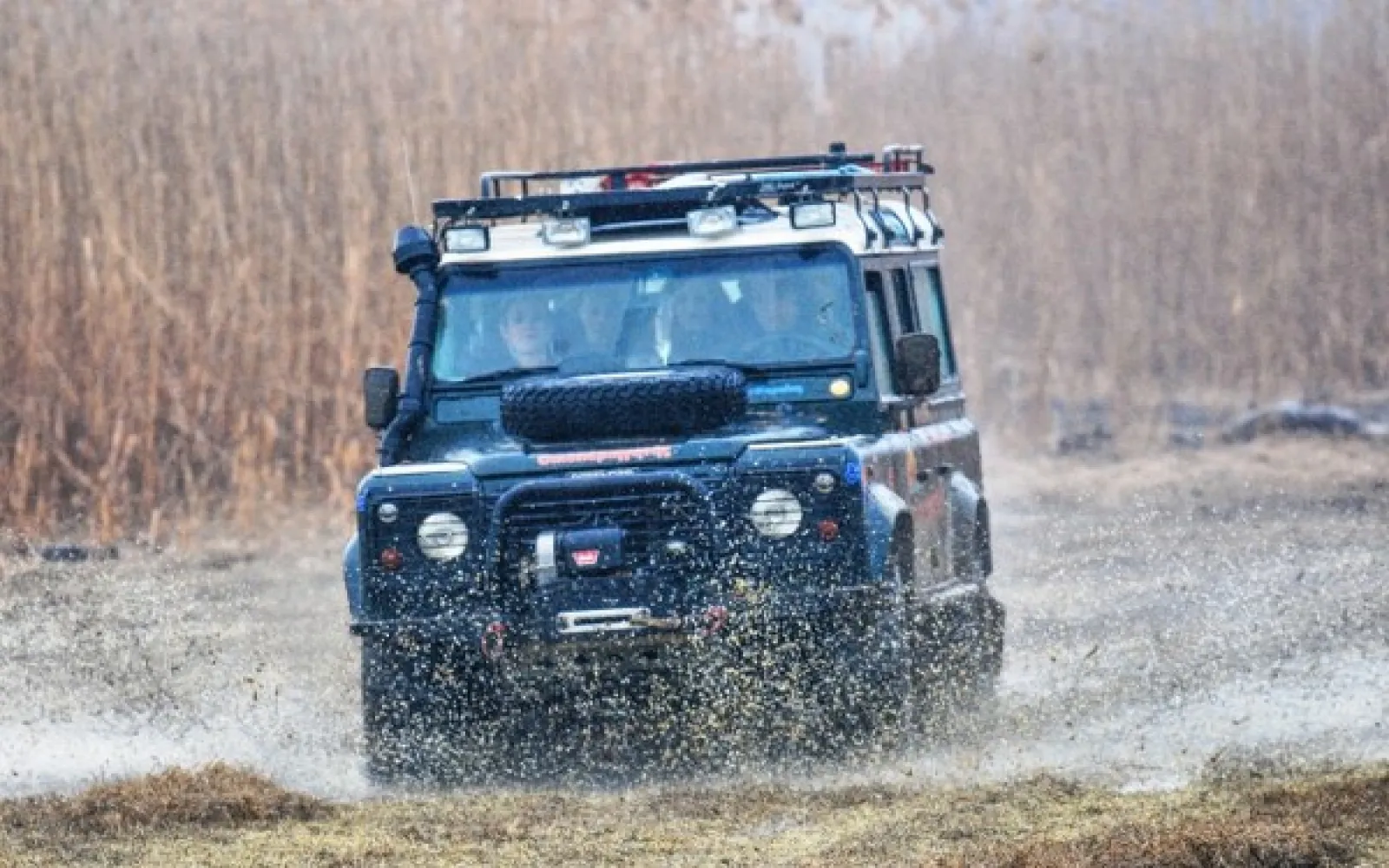 Land Rover Defender διασχίζει νερά κοντά στη λίμνη